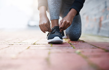 Image showing Exercise, tie and and laces of female athlete or running shoes or hands and healthy woman with knee on the floor. Training, work out and foot or lady runner starts fitness routine in closeup