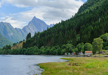 Image showing boathouse by the sea and mountains in the background