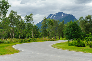 Image showing road bend between trees and mountains