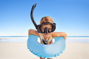 Image showing Portrait, beach and child with goggles and inflatable gear for swimming, summer holiday and happy outdoor adventure. Face of kid excited standing by the ocean or sea water excited for vacation