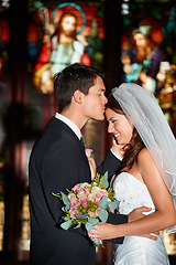 Image showing Wedding, marriage or ceremony with a bride and groom in a church or chapel for the tradition of vows. Married couple, love or trust with a man kissing a woman on the forehead as newlywed people