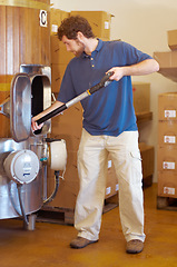 Image showing Beer, distillery and person manufacturing alcohol drink in the brewery industry or working on the fermentation process. Product, labour and young man making a craft in a storage or warehouse