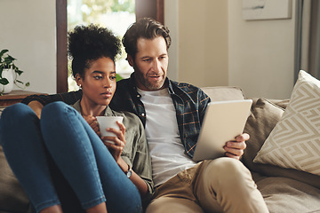 Image showing Love, home and couple with a tablet, connection and social media for communication, romance and relax. Partners, man and woman on a couch, interracial and technology for chatting, texting and bonding