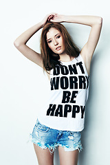 Image showing Portrait, young and a woman with a message on a shirt isolated on a white background in a studio. Fashion, stylish and a model with a tshirt and words of encouragement, empowerment and confidence