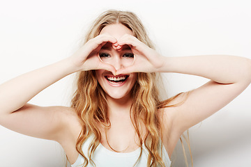 Image showing Portrait, smile and woman with heart shape, care and confident girl isolated against a white studio background. Face, female person and model with symbol for love, happiness and support with beauty