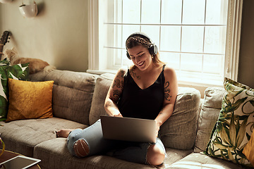 Image showing Computer, headphones and woman on sofa and music, happy work from home for mental health in apartment. Young person relax on couch and listening to audio technology, electronics and working on laptop