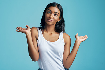 Image showing Choice, portrait and woman with option gesture in studio with question, thinking and doubt symbol. Decision, balance and female model with comparison or shrug hand sign by blue background with mockup