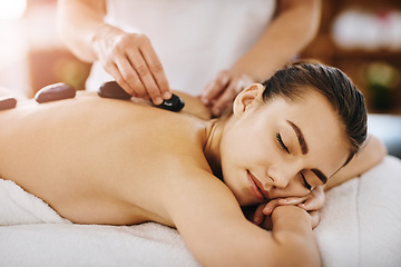 Image showing Therapy, relax and woman getting a hot stone back massage at spa for luxury, calm and natural self care. Beauty, body care and tranquil female person sleeping while doing rock body treatment at salon