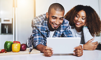 Image showing Happy couple, tablet and cooking healthy meal with recipe in kitchen at home on internet, website and online connection. Man, African woman and technology for reading instructions on vegan food blog