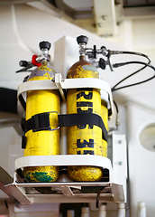 Image showing Oxygen tanks, metal and cylinders of emergency equipment, storage and fire department gear in important workplace, safety and medical supplies. Background, yellow and air container or rescue object