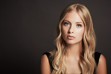 Image showing Portrait, face and beauty of a woman with makeup, cosmetics and hair shine in studio. Headshot of a female aesthetic model with skin glow, luxury skincare and mockup space on a dark background