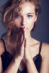 Image showing Portrait, hands together and woman with lingerie, fashion and confident girl against studio background. Face, female person and model with wellness, prayer and hope with glamour, elegant and sensual