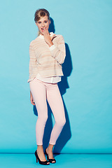 Image showing Portrait, wow and hand on mouth with a woman in studio on a blue background for surprise or shock. Fashion, gasp and hand gesture with an attractive young female model standing against a wall