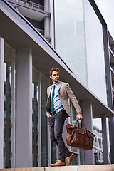 Image showing Professional, walking and businessman travel in the city in suit working at the office with hands. Young, man and corporate in front of urban buildings as a worker commutes to a startup company.