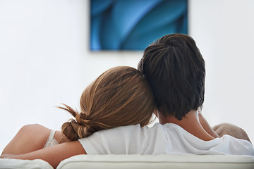 Image showing Back, relax and a couple watching tv on the sofa with affection, comfort and content at home. Calm, love and a man and woman sitting on the living room couch for a movie, film or show on television