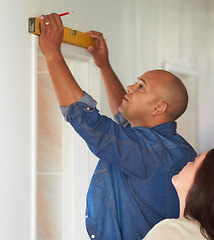 Image showing Spirit meter, man contractor and measure for maintenance, home improvement with wife. Construction, couple and male person with pencil drawing on a wall for level measuring of handyman and line