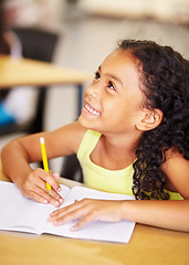 Image showing Happy, school and child writing in her book while listening to a lesson in the classroom. Happiness, smile and young girl kid student doing an education activity, studying or homework by her desk.