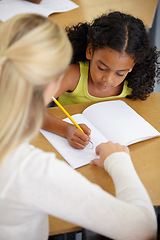 Image showing Teacher help child, education and writing in notebook with pencil, teaching and learning for growth and development. People in classroom to learn, academic study with young girl and woman at school