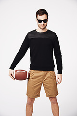 Image showing Sunglasses, fashion and man in studio with football for confident, pride and stylish clothing. Fitness, sport and portrait of male person with ball in funky, cool and trendy style on white background