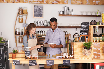 Image showing Business, man and woman with a tablet, cafe and explain process with planning, schedule and talking. Partnership, entrepreneur and employees with technology, profit growth and conversation in a store