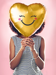 Image showing Love, smile and a woman with a heart balloon isolated on a pink background in a studio. Happy, cute and a girl holding a present or gift for valentines day or a birthday for care and happiness