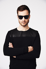 Image showing Sunglasses, fashion and man in studio with crossed arms for confidence, pride and stylish clothing. Portrait, style and serious male person with funky, cool and trendy eyewear on white background