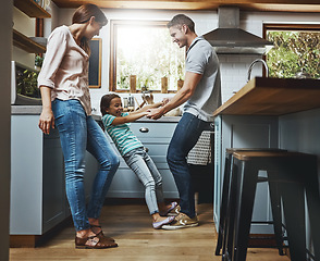 Image showing Family, kitchen and dance together in home or bonding, child and father holdings hands, love and quality time in house. Girl, dad and mom with affection, fun and relax or dancing and laughing