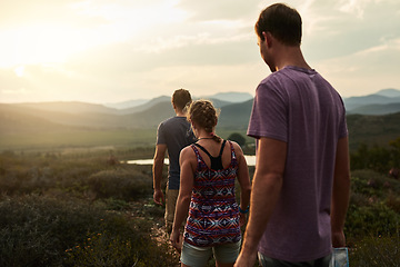 Image showing Friends, people hiking and trekking in nature with fitness, bond in countryside with travel together and freedom. Exercise, adventure with men and woman walking through meadow or field with back view