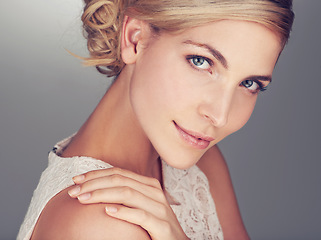 Image showing Woman, face and beauty with makeup, cosmetics and smile with blond hair posing against a studio background. Portrait of beautiful and attractive young white female model smiling with hand on shoulder