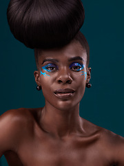 Image showing Portrait, hair care and makeup with a model black woman in studio on a blue background for fashion. Face, hairstyle and cosmetics with a beautiful young female person at a salon for beauty or styling