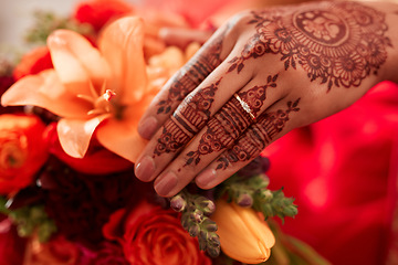 Image showing Henna, hand and Indian bride at her wedding event with flowers or bouquet for decoration or design. Event, marriage and creative female person or woman with art pattern on her hand for celebration