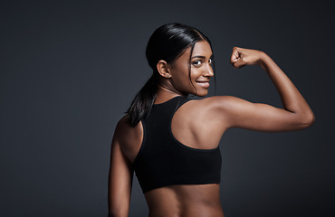 Image showing Portrait, happy and woman flexing back in studio isolated on a black background mockup. Strong flex, smile and Indian female athlete with bicep, arm strength or bodybuilder muscle, fitness or workout