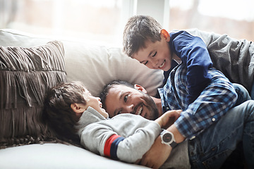 Image showing Father, boy children and laughing together, fun and carefree with love, energy and happy at family home. Man play with kids on sofa, crazy and playful with happiness and excited with laughter