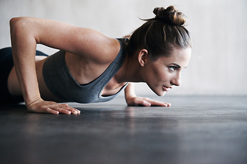 Image showing Fitness, pushup and woman on a floor for training, cardio and endurance at gym. Lifting, exercise and female athlete at a health center for core, strength and ground workout with determined mindset