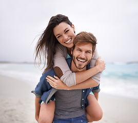 Image showing Couple, portrait and piggyback hug at beach for travel, romance and freedom together outdoors. Face, smile and happy woman embracing man on trip, vacation or holiday, bond and having fun in Florida