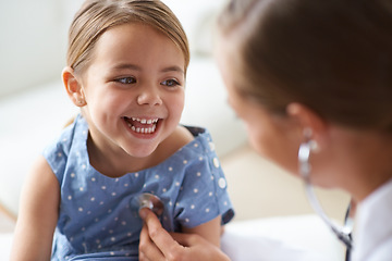Image showing Happy girl, kid and pediatrician with stethoscope for medical consulting, healthy lungs and listening to heartbeat. Face of child, doctor and chest assessment, healthcare analysis and smile in clinic
