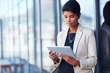 Image showing Tablet, mockup and corporate with a business woman leaning against a glass wall or window at the office. Technology, research and space with a young professional female employee working online