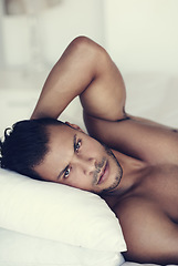 Image showing Man, face relax shirtless in bed and in bedroom of his home. Confident, serious and topless male model laying with hot guy look in the morning for skincare or body wellness after a wake up