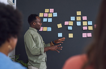 Image showing Meeting, brainstorming and planning with team, black man speaker, sticky note and leader in presentation. Collaboration, teamwork and people in strategy workshop, ideas with presenter and audience