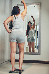 Image showing Celebration, weight loss goal and woman with scale and diet success in a home with mirror reflection. Cheering, happy and female person in a house with nutrition progress and a smile from wellness