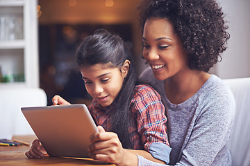 Image showing Family, children or tablet with a mother and daughter busy with homework for education in the home together. Love, study or technology with a parent and female child bonding while learning in a house