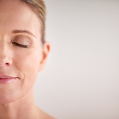 Image showing Beauty, mockup and half face with a woman in studio on a gray background for cosmetic skincare advertising. Facial, wellness and eyes closed with a senior female model posing for natural skin care