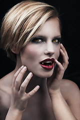 Image showing Portrait, hands and a woman vampire in studio on a dark background for halloween or cosplay. Fantasy, horror or fangs with an attractive young female monster posing as an evil and surreal creature