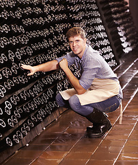 Image showing Portrait, man and counting bottles of wine in cellar, warehouse or factory. Alcohol, manufacturing and male person count, happy inspection or quality control at production plant, winery or distillery