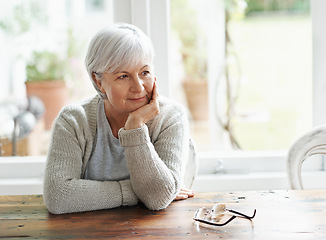 Image showing Senior woman, home and thinking of nostalgia, memory and relaxing retirement with hope for vision at table. Happy elderly grandma daydream of history, aging process and wisdom of thoughtful memories