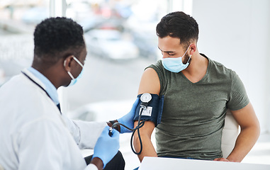 Image showing Covid, mask and doctor exam hypertension of a patient in a hospital or cardiology test by medical worker in a clinic. Health, man and professional healthcare employee consulting for blood pressure