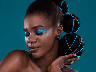 Image showing Face, hand and hair with a model black woman in studio on a blue background for hair or cosmetics. Eyes closed, makeup and fashion with an attractive young female person posing to promote beauty