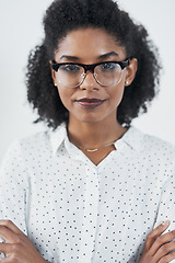 Image showing Serious, business and portrait of black woman with arms crossed in studio isolated on white background. Glasses, confidence or face of African female professional, entrepreneur or person from Nigeria