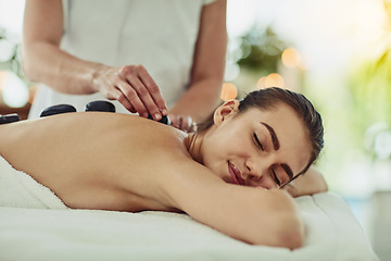 Image showing Health, relax and woman getting a hot stone back massage at spa for luxury, calm and natural self care. Beauty, body care and tranquil female person sleeping while doing rock body treatment at salon.