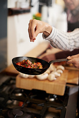 Image showing Hand, cooking and seasoning with a chef in the kitchen for meal preparation in a home for dinner. Healthy, diet and nutrition with food in a pan for wellness, hunger or satisfaction in a house